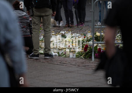 Turku, Finlande. 19 août 2017. Les gens plaçant bougies et fleurs sur le lieu d'agression au couteau dans la place du marché de Turku. Deux personnes ont été tués et six autres blessés dans une agression au couteau qui a eu lieu le vendredi 18 août à la place du marché de Turku et Puutori. La police a réussi à arrêter l'attaquant en quelques minutes après le premier appel d'urgence en tirant sur lui à la cuisse. Enquête sur l'attaque de la police comme un acte de terrorisme. Credit : Jarmo Piironen/Alamy Live News Banque D'Images