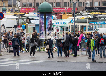 Turku, Finlande. 19 août 2017. Les gens plaçant bougies et fleurs sur le lieu d'agression au couteau dans la place du marché de Turku. Deux personnes ont été tués et six autres blessés dans une agression au couteau qui a eu lieu le vendredi 18 août à la place du marché de Turku et Puutori. La police a réussi à arrêter l'attaquant en quelques minutes après le premier appel d'urgence en tirant sur lui à la cuisse. Enquête sur l'attaque de la police comme un acte de terrorisme. Credit : Jarmo Piironen/Alamy Live News Banque D'Images