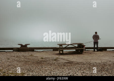 Un pêcheur solitaire sur les quais à Fort Wetherill à Jamestown, RHODE ISLAND. Banque D'Images