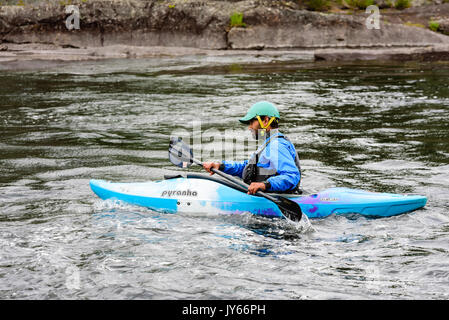 Byglandsfjord, Norvège - 1 août 2017 : Voyage documentaire de personne kayak en rivière calme à l'eau kayak Pyranha bleu. Banque D'Images