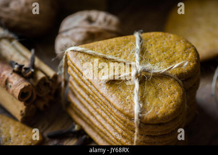 Pile d'épices biscuits de Noël fait maison dans le style scandinave liés avec de la ficelle, des bâtons de cannelle, girofle, noix, ambiance chaleureuse de fête, kinfol Banque D'Images