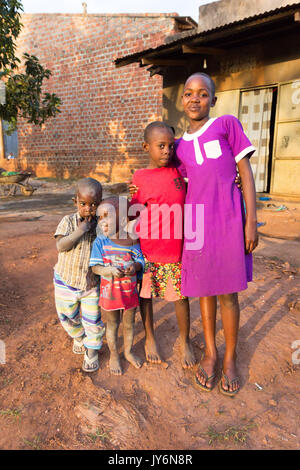 Un groupe d'enfants de l'Afrique de l'smilng, ensemble pour le bien d'une photographie. Les enfants sont en face d'une simple cabane en bois, ils sont probabl Banque D'Images