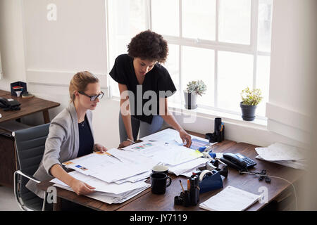 Deux jeunes femmes l'étude de documents dans un bureau Banque D'Images