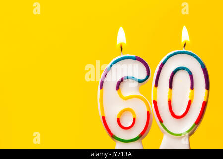 Bougie célébration de l'anniversaire de numéro 60 contre un arrière-plan jaune vif Banque D'Images