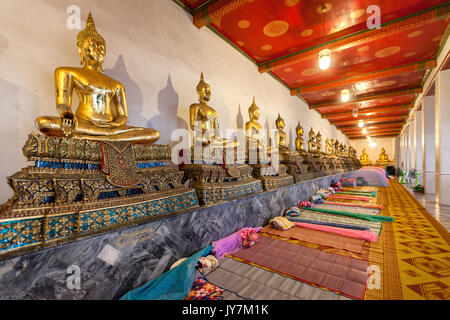 Rangée de bouddhas assis d'or priant au Wat Pho (Temple du Bouddha couché), Bangkok, Thaïlande Banque D'Images