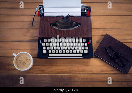 Vue de dessus de typewriter par tasse à café et livre sur table en bois Banque D'Images