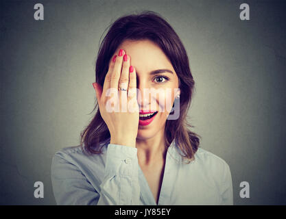 Portrait de jeune femme surprise couvrant la moitié le visage avec sa main Banque D'Images