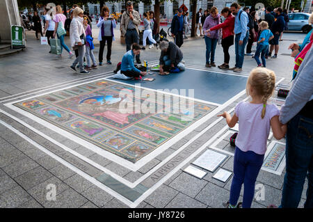 Les touristes les gens regarder la chaussée trottoir rue artistes au travail sur O'Connell Street Upper, Dublin, Irlande Banque D'Images