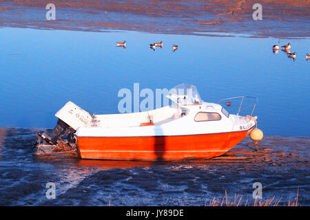 Seascape lumineux orange et bateau en saison d'hiver, Angleterre Essex Maldon. Banque D'Images