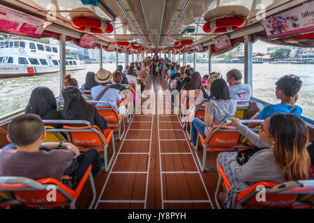 Bateau Express intérieur avec des passagers assis et les touristes sur la rivière Chao Phraya à Bangkok, Thaïlande Banque D'Images