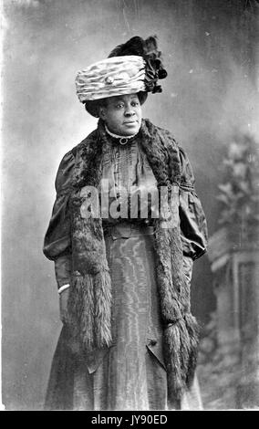 Portrait d'un african american woman standing, portant un chapeau et étole de fourrure, 1915. Banque D'Images