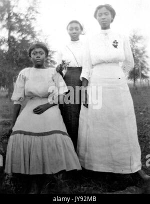 Portrait de mère afro-américaine et des filles portant des tenues, dans le plein air, 1930. Banque D'Images