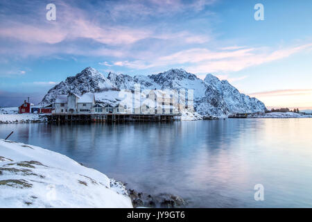 Petit groupe de maisons de pêcheurs entouré de neige dans le port de henningsvær. Iles Lofoten. Norvège europe. Banque D'Images