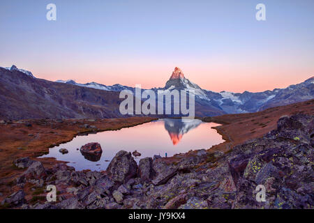 Les randonneurs admirer le Cervin reflète dans le Stellisee au lever du soleil. Zermatt Canton du Valais Alpes Pennines Suisse Europe Banque D'Images