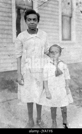 Portrait de deux frères afro-américains, les deux jeunes filles portent des vêtements de couleur claire, la fille plus âgée a sa main sur l'épaule de la jeune fille, 1920. Banque D'Images