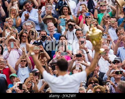 Roger Federer montrant trophée pour les spectateurs dans les tribunes à Wimbledon Banque D'Images