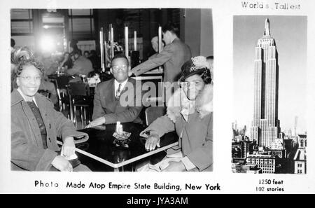 Un homme afro-américain et deux femmes dans une photo prise au sommet de l'Empire State Building, un souvenir touristique montrant l'homme et les femmes assis à une table dans un café, avec une image de l'Empire State Building et une légende lisant les mondes plus hauts, New York, New York, 1932. Banque D'Images