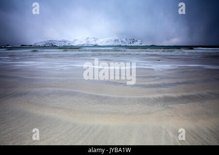 Vagues de la mer de glace sur la plage à l'arrière-plan les sommets enneigés Ramberg Lofoten, Norvège Europe Banque D'Images