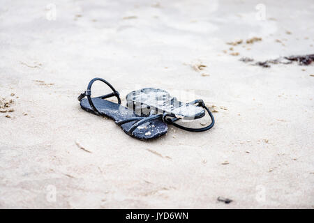 Chaussures noires dans le sable de plage blanc Banque D'Images