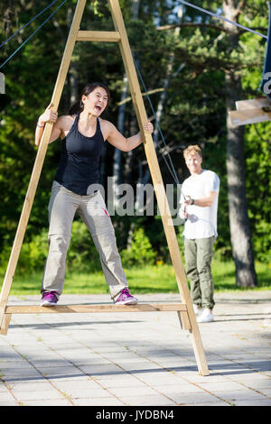 Femme criant sur la structure tout en tirant sur des cordes ami Patio Banque D'Images
