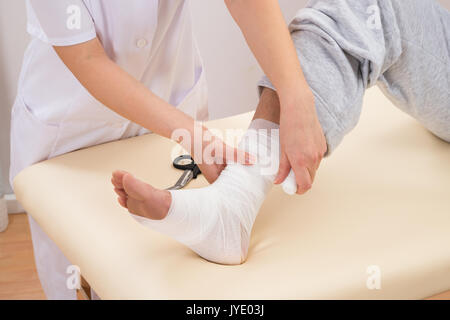 Close-up of a Woman Lier Bandage sur pied du patient Banque D'Images