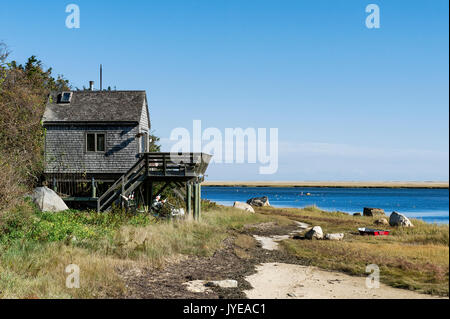 La plage pittoresque cottage sur pilotis avec barque le long de Weeset Nauset Harbour, Point, Cape Cod, Massachusetts, États-Unis. Banque D'Images