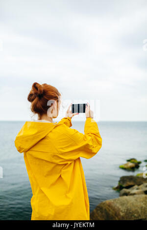 Girl taking photo of ocean Banque D'Images