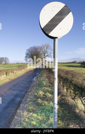 La limite de vitesse nationale signe sur Narrow country Road Banque D'Images