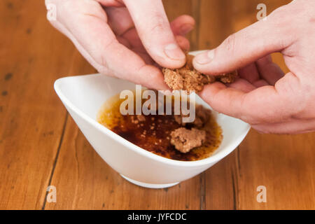 Un chef ajoute quelques biscuits pour une crème brûlée Banque D'Images