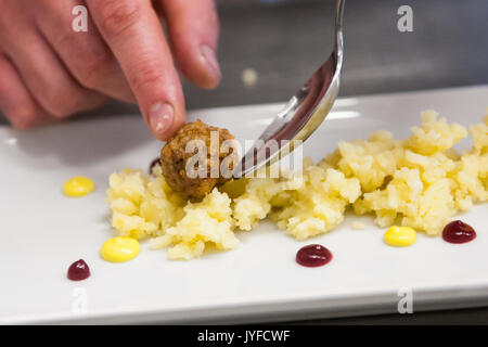 Un chef d'une des plaques sur un tapis de boulettes de pommes de terre Banque D'Images