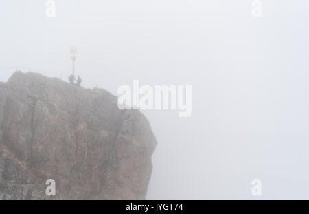 Grainau, Allemagne. Août 19, 2017. Deux alpinistes se tiennent près de la Sommet cross sous la pluie et brouillard à la Zugspitze à Grainau, Allemagne, 19 août 2017. Photo : Sven Hoppe/dpa/Alamy Live News Banque D'Images