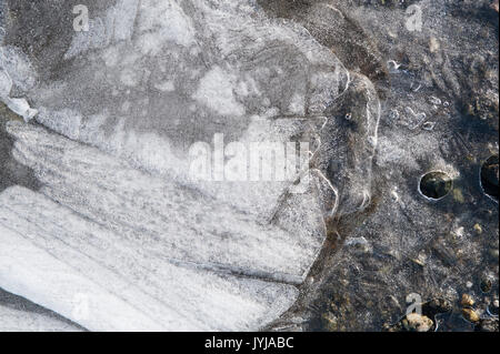 Mares gelées avec feuilles congelés dans la glace feuille de production de motifs et d'images abstraites, avec des plaques de glace parties Banque D'Images