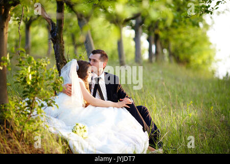 Embrasser la mariée et le marié dans le jardin. Banque D'Images