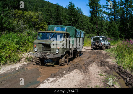 Gros camion hors route tire pross petits VUS. Tirez sur la voiture coincé dans la boue. Banque D'Images