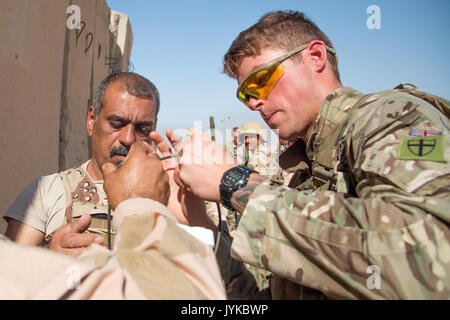 Les forces de sécurité irakiennes les membres reçoivent de l'aide d'un formateur de l'armée britannique durant le cours de génie de combat à la gamme Besmaya complexe, l'Iraq, le 8 août 2017. La gamme Besmaya complexe est l'un des quatre Combined Joint Task Force - Fonctionnement résoudre inhérent à renforcer les capacités des partenaires endroits consacre à la formation des forces des partenaires et renforcer leur efficacité sur le champ de bataille. Les GFIM-OIR est la Coalition mondiale pour vaincre ISIS en Iraq et en Syrie. (U.S. Photo de l'armée par le Sgt. Tracy McKithern) Banque D'Images