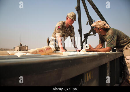 Une armée britannique trainer accompagne un membre des forces de sécurité irakiennes de déminage au cours de formation à la charge de la ligne Besmaya complexe gamme, l'Iraq, le 10 août 2017. La gamme Besmaya complexe est l'un des quatre Combined Joint Task Force - Fonctionnement résoudre inhérent à renforcer les capacités des partenaires endroits consacre à la formation des forces des partenaires et renforcer leur efficacité sur le champ de bataille. Les GFIM-OIR est la Coalition mondiale pour vaincre ISIS en Iraq et en Syrie. (U.S. Photo de l'armée par le Sgt. Tracy McKithern) Banque D'Images