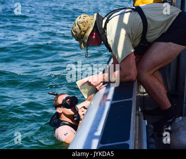 Les étudiants du Naval Diving and Salvage Training Center collaborent lors d’un exercice de plongée et de sauvetage dans le golfe du Mexique. Les officiers de sauvetage de combat participent aux côtés du personnel enrôlé pour pratiquer des opérations sous-marines, le travail d'équipe et les procédures d'intervention d'urgence dans un environnement d'entraînement contrôlé. Banque D'Images