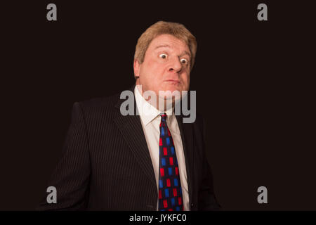 Studio shot of senior businessman en colère contre le fond sombre Banque D'Images