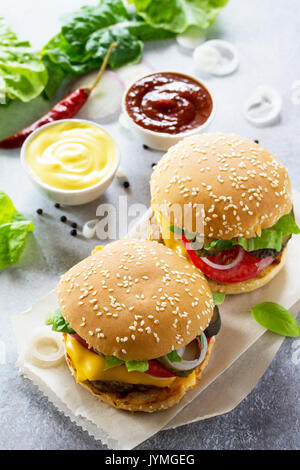 Un délicieux hamburger maison sur une table en pierre ou en ardoise. Banque D'Images