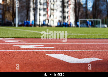 Piste de course rouge libre dans le stade, les joueurs de football ou soccer floue Banque D'Images