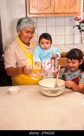 Grand-mère grand-mère hispanique petit-enfant aide aide l'enseignement de l'enfant fille mignonne travail travailler woman holding baby bébé sage sagesse aidants familiaux ©  = = Banque D'Images