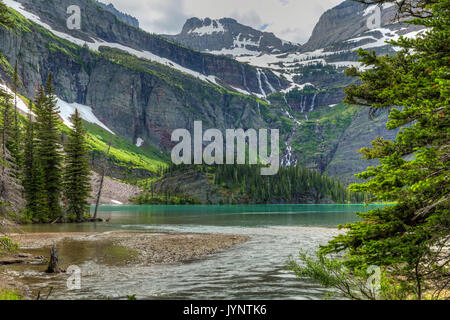 Une cascade s'écoule du glacier Grinnell en turquoise Grinnell Lake dans le Glacier National Park, Montana Banque D'Images