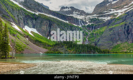 Une cascade s'écoule du glacier Grinnell en turquoise Grinnell Lake dans le Glacier National Park, Montana Banque D'Images