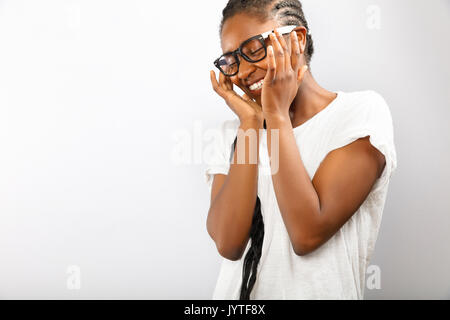 Heureux et souriant femme africaine avec des lunettes en chemise blanche Banque D'Images