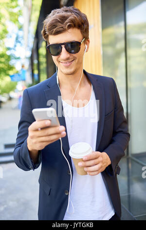 Jeune homme élégant d'écouter de la musique en plein air Banque D'Images