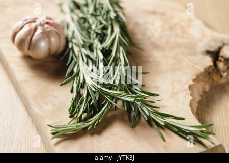 Bouquet de romarin et l'ail sur table en bois Banque D'Images