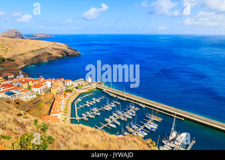 Vue sur port de plaisance avec location de bateaux et maisons colorées près de Canical ville sur la côte de l'île de Madère, Portugal Banque D'Images