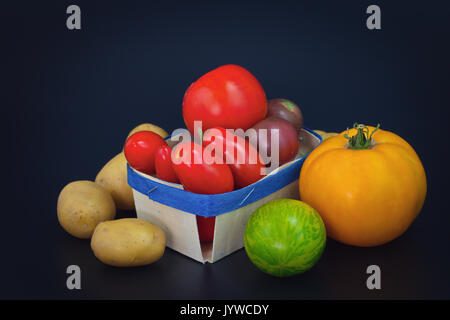 Assortiment de légumes bio tomates et pommes de terre colorés sur fond noir Banque D'Images