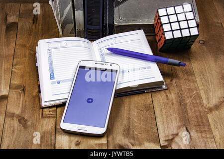 Books, agenda avec stylo, smartphone et cube Rubik se situent sur une surface en bois Banque D'Images