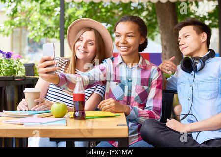 Les jeunes prenant en Selfies Cafe Banque D'Images